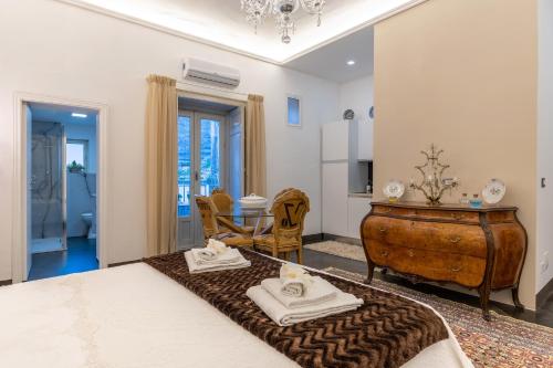 a room with a bed and a table with towels at Dimora D'Incanto in Ragusa