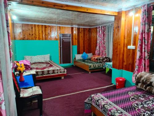 a room with three beds and a couch and a chair at Jasshanti Homestay by StayApart in Jālāpahār