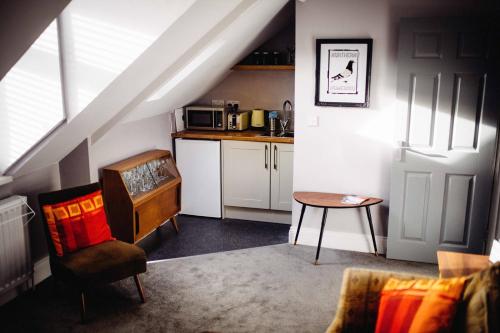 een kamer met een keuken met een tafel en een stoel bij Docker's Digs in Gateshead