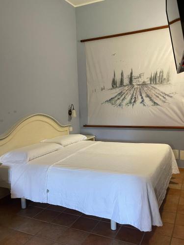 a bedroom with a bed with a painting on the wall at Le Calvie, country house in Camerino