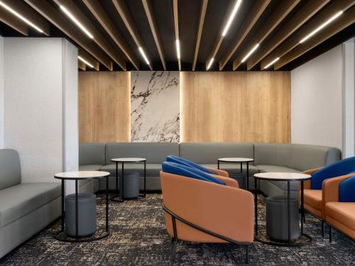 a waiting room with couches and tables at Hyatt Place Kansas City/Overland Park/Metcalf in Overland Park