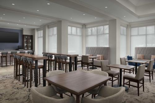 a restaurant with tables and chairs and a flat screen tv at Hilton Garden Inn Atlanta North/Johns Creek in Johns Creek