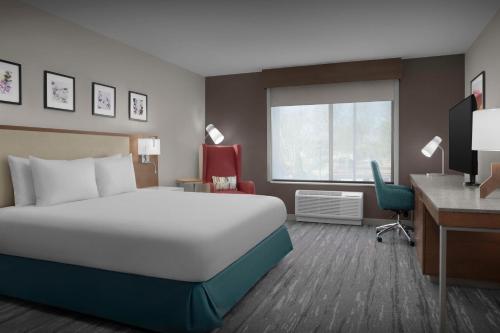 a hotel room with a large bed and a desk at Hilton Garden Inn Atlanta North/Johns Creek in Johns Creek