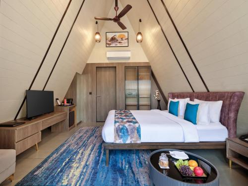 a hotel room with a bed and a tv at Regenta Resort Vindhyachal, Statue of Unity in Kevadia
