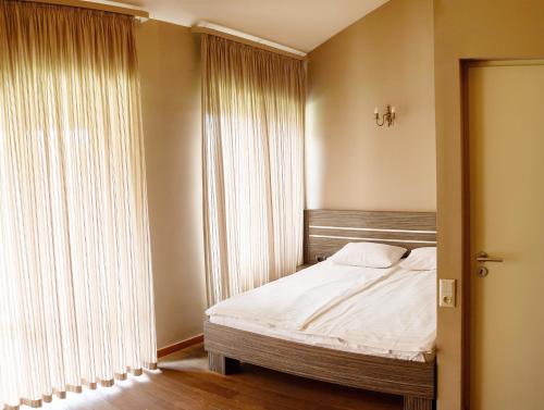 a bedroom with a bed and a large window at Teghenis Resort in Tsaghkadzor