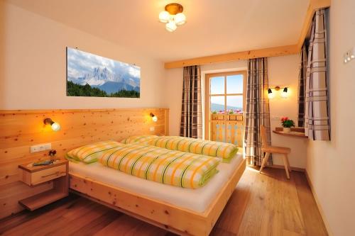 a bedroom with a large bed in a room at Mitterhof in Villandro