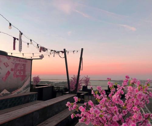 a view of the sunset from a restaurant with pink flowers at Story Hotel Studio Malmo, part of JdV by Hyatt in Malmö