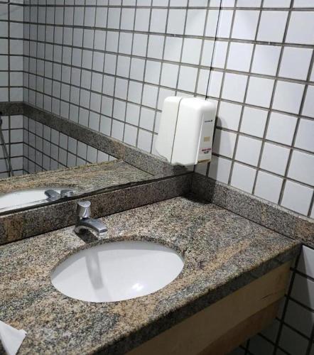 a bathroom counter with a sink and a soap dispenser at Flat hotel number one 403 in São Luís