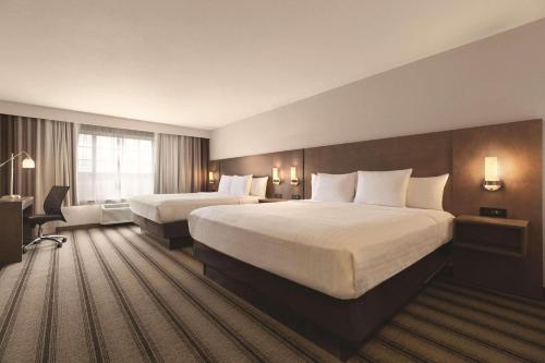 a hotel room with two beds and a large window at Country Inn & Suites by Radisson, Billings, MT in Billings