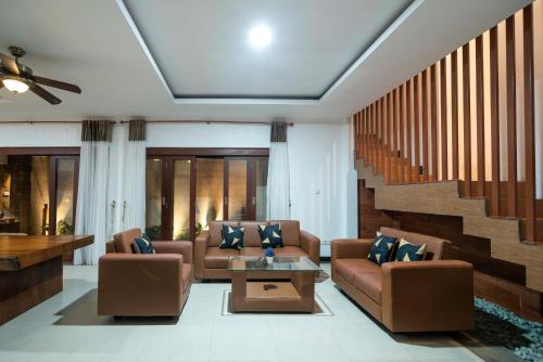 a living room with two couches and a table at Lamin Etan Saba Selatan in Keramas