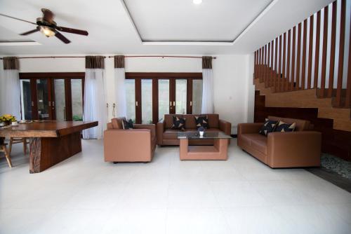 a living room with couches and a table at Lamin Etan Saba Selatan in Keramas