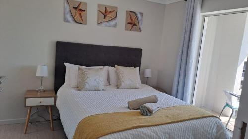 a bedroom with a large bed and a window at Breezy Sunny Apartment in Cape Town