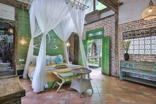 a bedroom with a bed with a white canopy at Pramana Giri Kusuma in Payangan