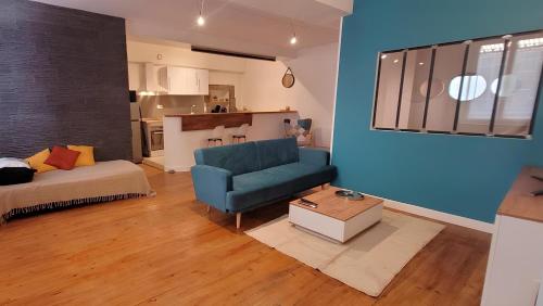 un salon avec un canapé bleu et une table dans l'établissement Le Petit Loft de Saint Herem, à Clermont-Ferrand