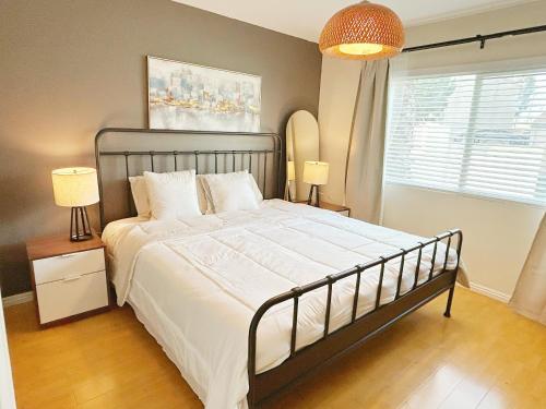 a bedroom with a bed and two lamps and a window at Brea Mall romantic two-bedroom house in Fullerton