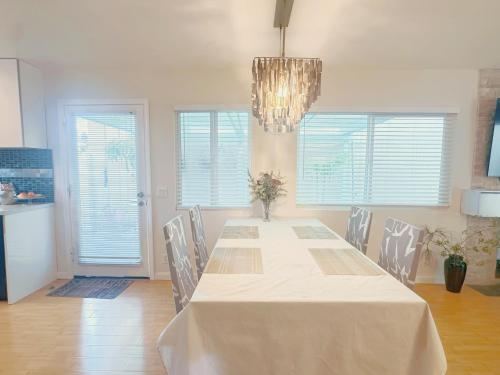a dining room with a table and chairs and a chandelier at Brea Mall romantic two-bedroom house in Fullerton