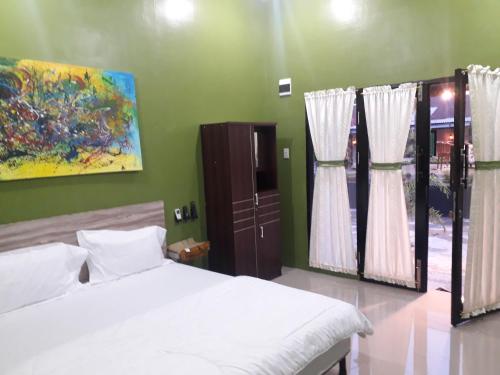 a bedroom with two beds and a painting on the wall at Ahza syariah in Rantauprapat