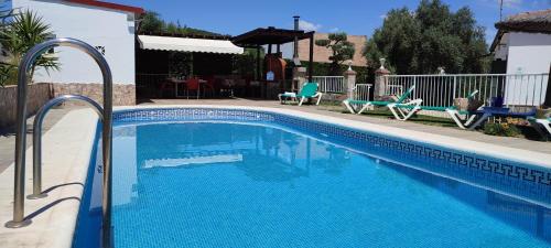 a swimming pool with blue water in a yard at Casa cerrito in Prado del Rey