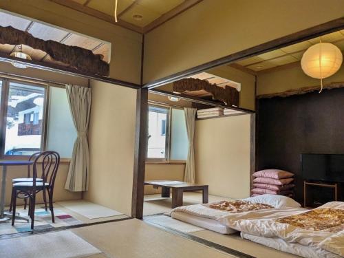 a bedroom with two bunk beds and a table at Bamboo-Hill -OT- in Nozawa Onsen