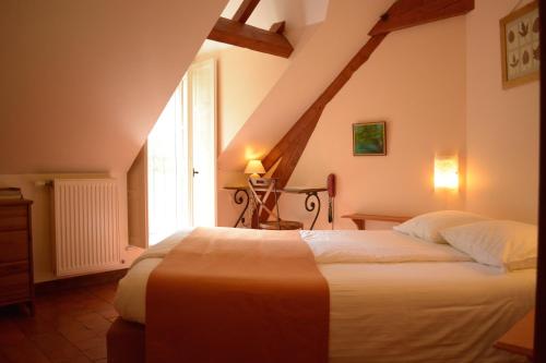 ThuryにあるManoir Bonpassageのベッドルーム1室(屋根裏部屋に大型ベッド1台付)