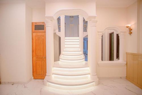 a white staircase in a room with a wooden door at Hotel Permata Malioboro in Yogyakarta