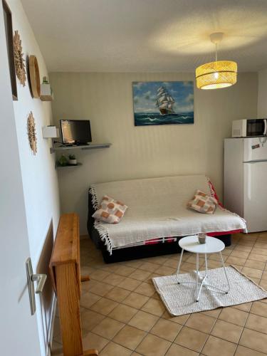 Cette petite chambre comprend un lit et une petite table. dans l'établissement Le Palm Beach vue mer le Barcares, au Barcarès