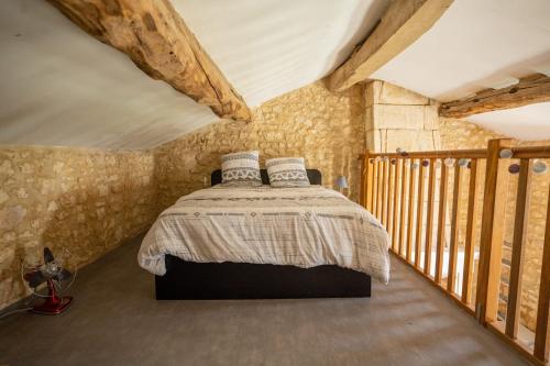 a bedroom with a bed in a room with stone walls at Havre de paix en Charente Maritime avec 3 formules d hébergement sur mesure de 1 à 14 voyageurs in Gémozac