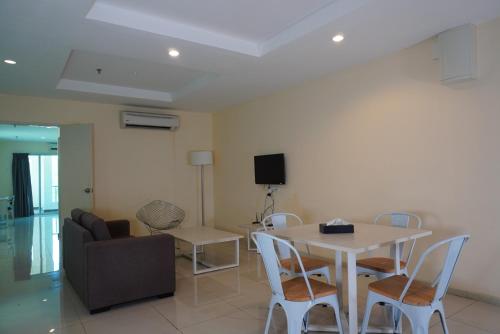 a living room with a table and chairs and a couch at Okay Marina Lumut Homestay in Lumut