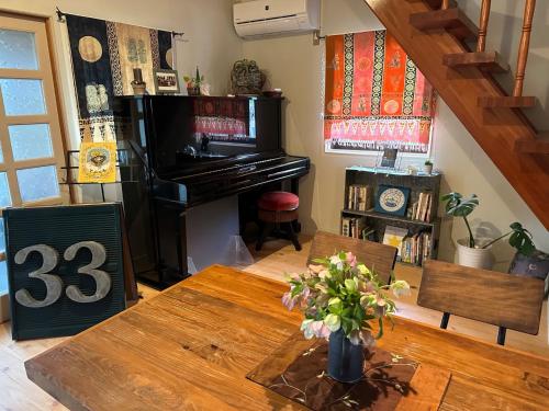 a living room with a table and a piano at Woman Only Ohenro House33 - Vacation STAY 27239v in Kochi