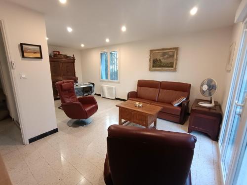 a living room with a couch and a table at Grand appartement, 2 chambres et jardin in Nîmes