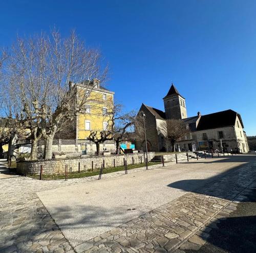 a large building with a tower and a church at Villa charmante à Montfaucon avec piscine privée in Montfaucon