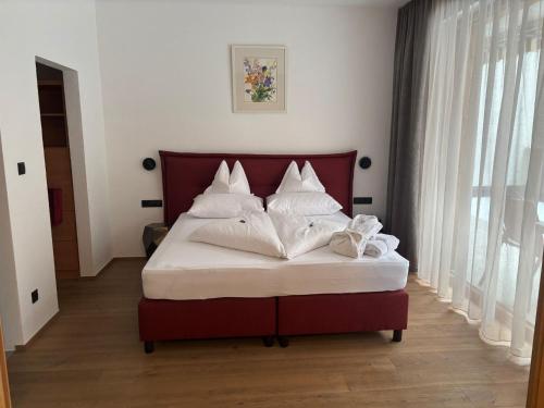 a bed with white pillows on it in a room at Urbanhof in Sölden