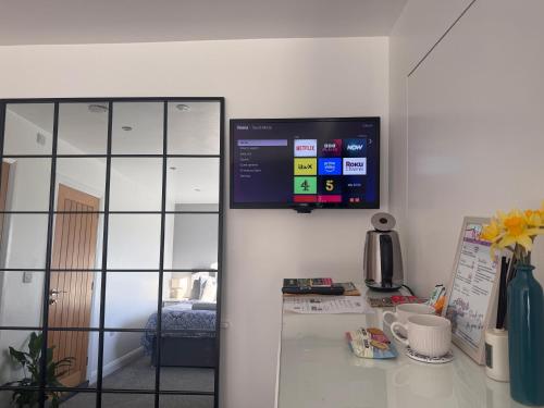 a room with a counter with a tv on the wall at Abbey’s Inn in Cheadle