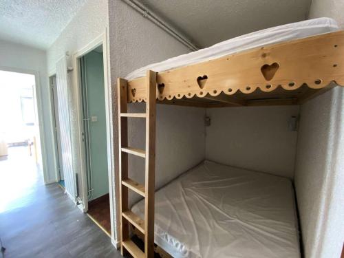 Ce lit superposé se trouve dans une chambre située à côté d'une porte. dans l'établissement Résidence Diamant 1 - Joli studio au plein cœur de la station des Deux Alpes avec balcon plein SUD MAE-9571, à Vénosc