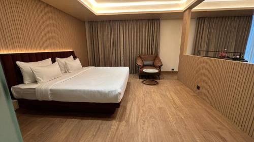 a hotel room with a bed and a chair at 37th Crescent Navi Mumbai in Mumbai