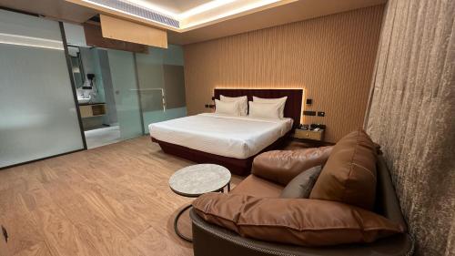 a hotel room with a bed and a couch at 37th Crescent Navi Mumbai in Mumbai