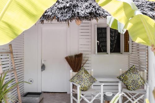 a porch with two chairs and a door at The Loop Beach Resort in Jambiani
