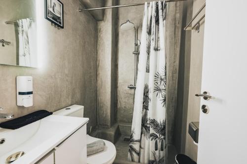 アテネにあるAura Suite by Zeussuitesのシャワーカーテンとトイレ付きのバスルーム
