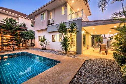 a house with a swimming pool in front of it at Grande Pool Villa BBQ&Pool party in Bang Sare