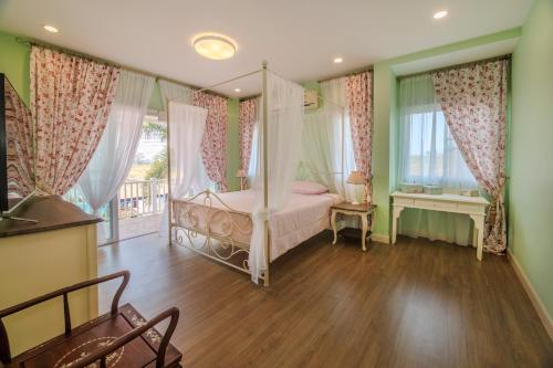 a bedroom with a canopy bed and a window at Grande Pool Villa BBQ&Pool party in Bang Sare