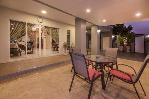 a dining room with a table and chairs and a clock at Grande Pool Villa BBQ&Pool party in Bang Sare
