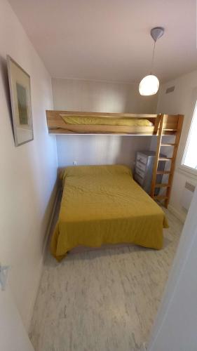 une chambre avec un lit avec un couvre-lit jaune dans l'établissement Appartement 2 pièces climatisé 3 couchages, Belle Terrasse VUE MER à Portiragnes plage LXBFM9, à Portiragnes
