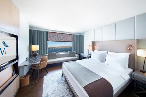 a hotel room with a large bed and a couch at The Marmara Taksim in Istanbul