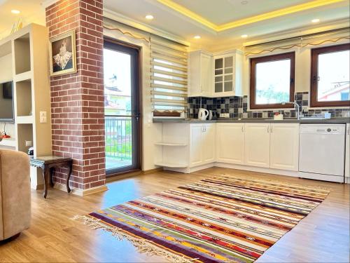 a kitchen with white cabinets and a brick pillar at Centrally Located Very Large Villa W Pool Jakuz and Car Park in Fethiye