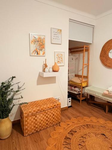 a room with a wicker ottoman in front of a bedroom at Paraíso a Dois em Estremoz in Estremoz