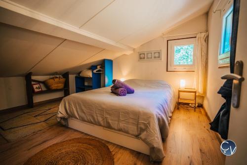 un ours en peluche violet allongé sur un lit dans une chambre dans l'établissement La Marjelle, Havre de paix en pleine nature avec piscine, à Montclus