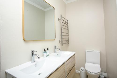 ストロイスバーイにあるCasa Azul Upstairs Apartmentの洗面台、鏡、トイレ付きのバスルーム