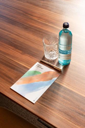 a bottle and a glass on a wooden table at Hotel Meliá Bilbao in Bilbao