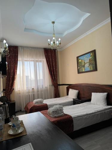 a hotel room with two beds and a couch at Belon Life Hotel in Astana