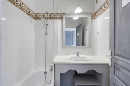 une salle de bain blanche avec un lavabo et une douche dans l'établissement Bellevue 4 pers - Les issambres - piscine - vue mer, à Roquebrune-sur Argens